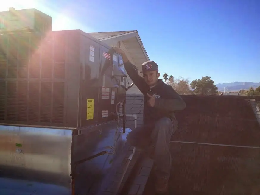 HVAC technician performing AC Tune-Up on a rooftop unit in Kenwood